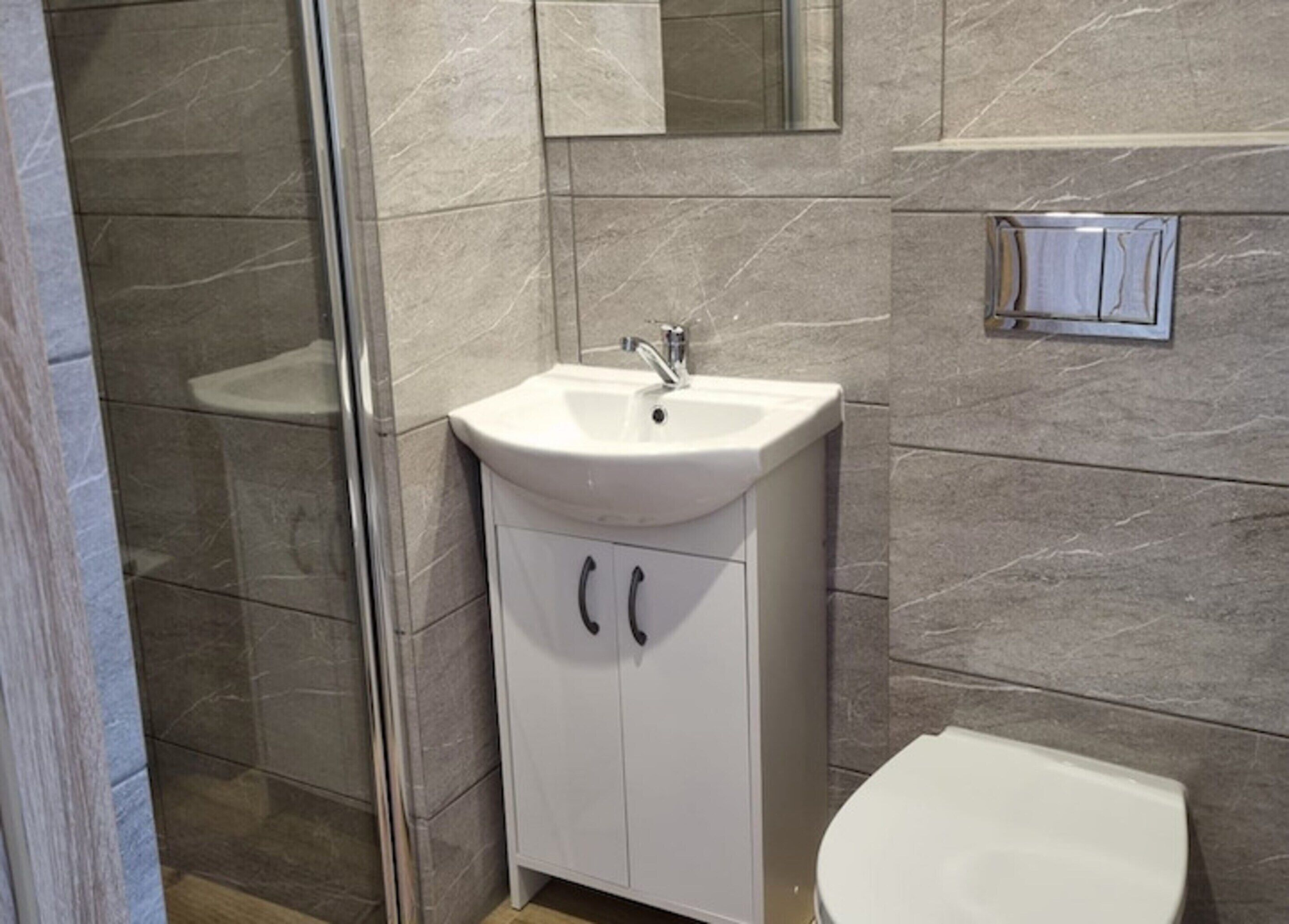 Un baño con un lavabo blanco, un espejo y un inodoro.