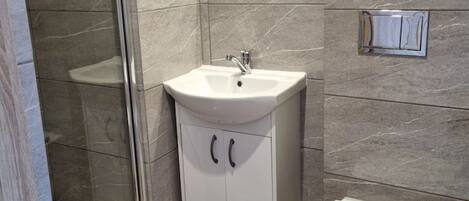 Un baño con un lavabo blanco, un espejo y un inodoro.