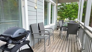 A wooden deck with outdoor furniture, including chairs and a grill. - Villa Chalet, Himos Länsihuippu (Jämsä)