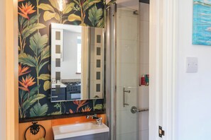 A bathroom with a shower, a sink, and a mirror. - Little Moorgate (Okehampton)