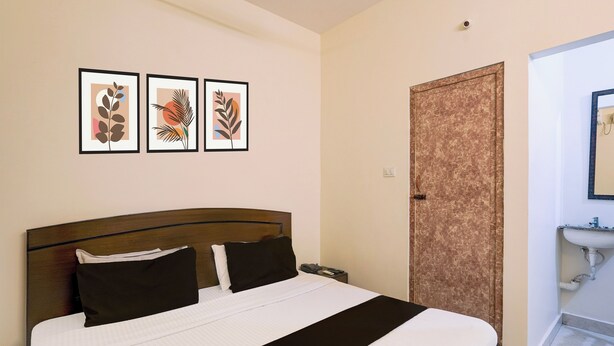Una habitación de hotel con cama, puerta y baño con lavabo.