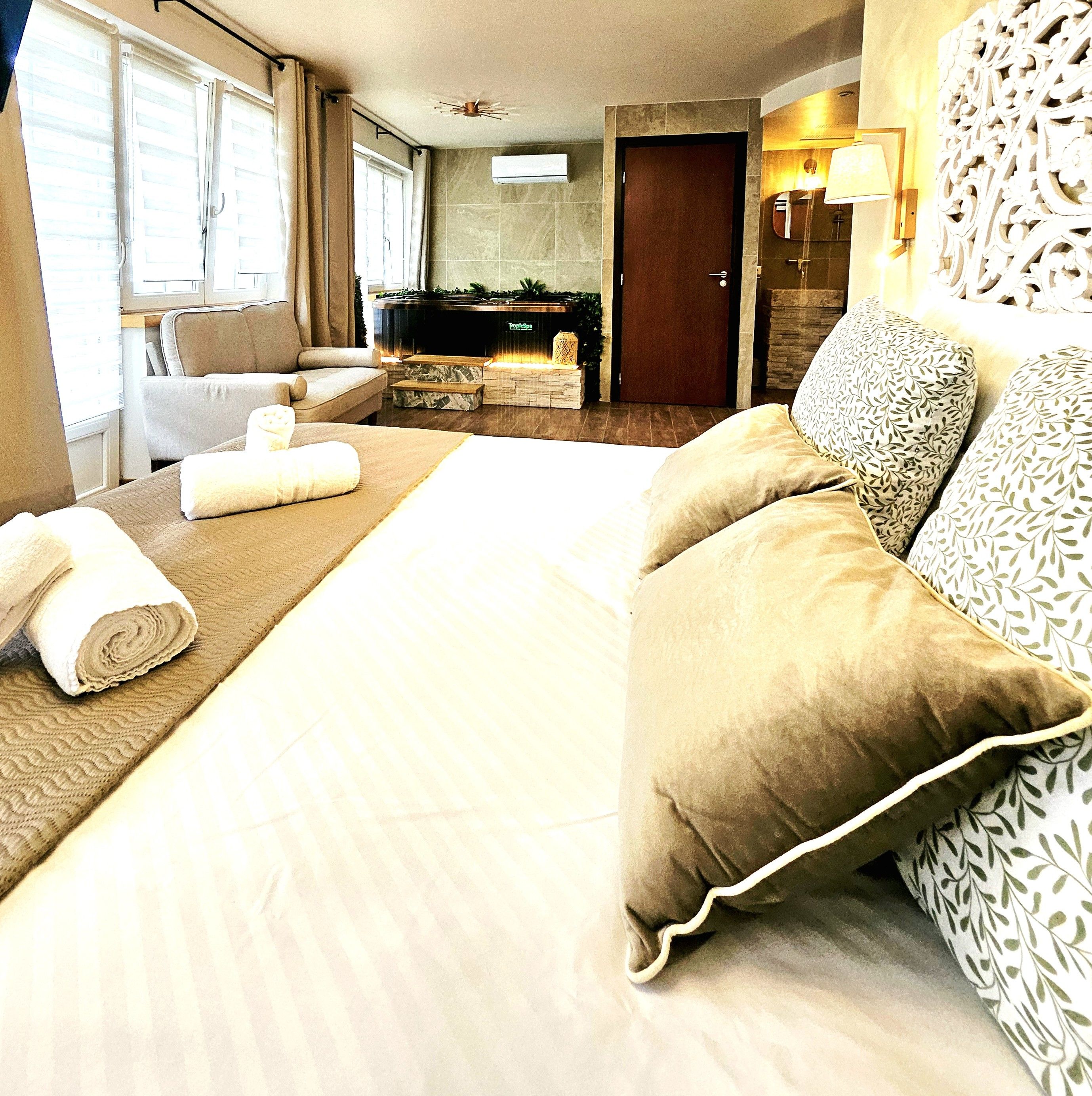 Une chambre d’hôtel avec un grand lit, un canapé, une table basse et une cheminée.