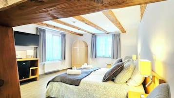 Un dormitorio con una cama grande, un escritorio y un armario.