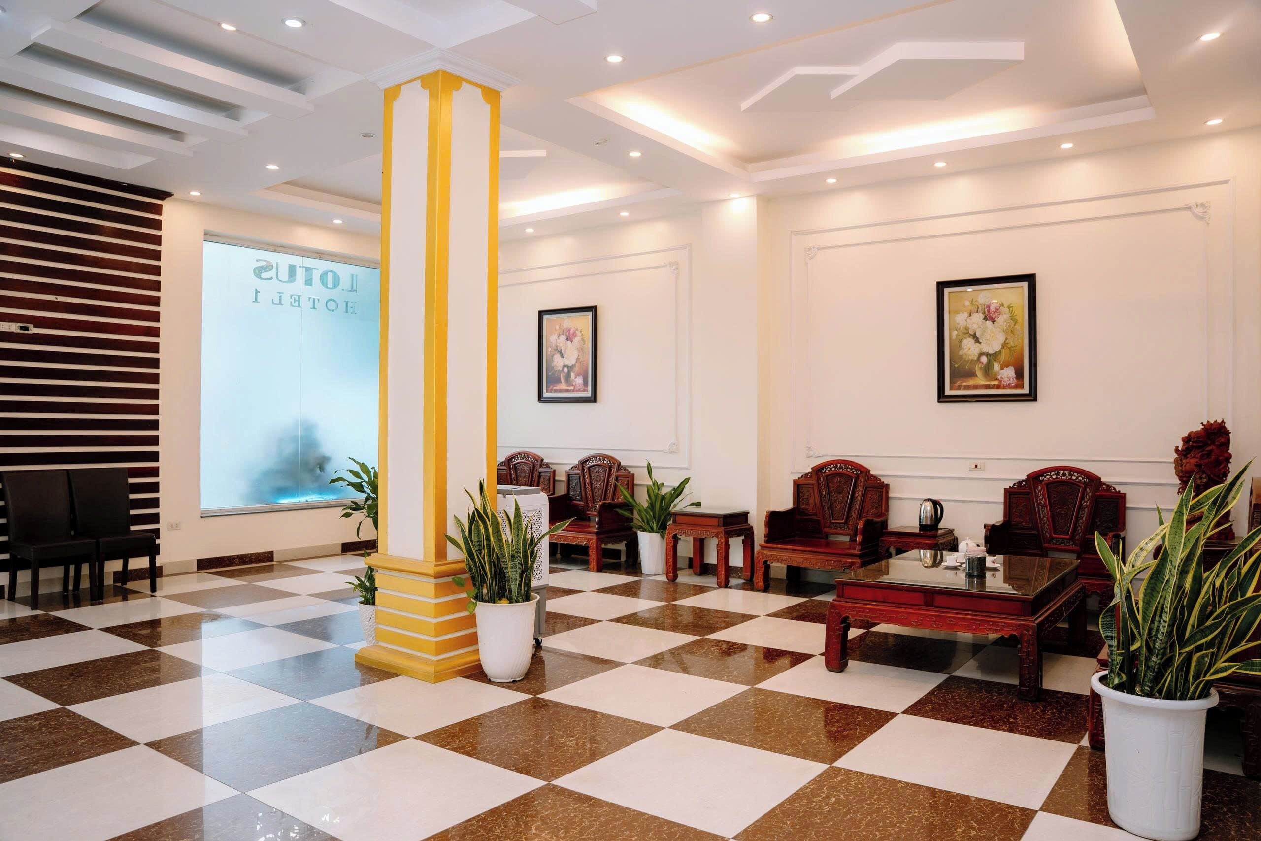 A lobby with a checkered floor, a large pillar, and traditional wooden furniture.