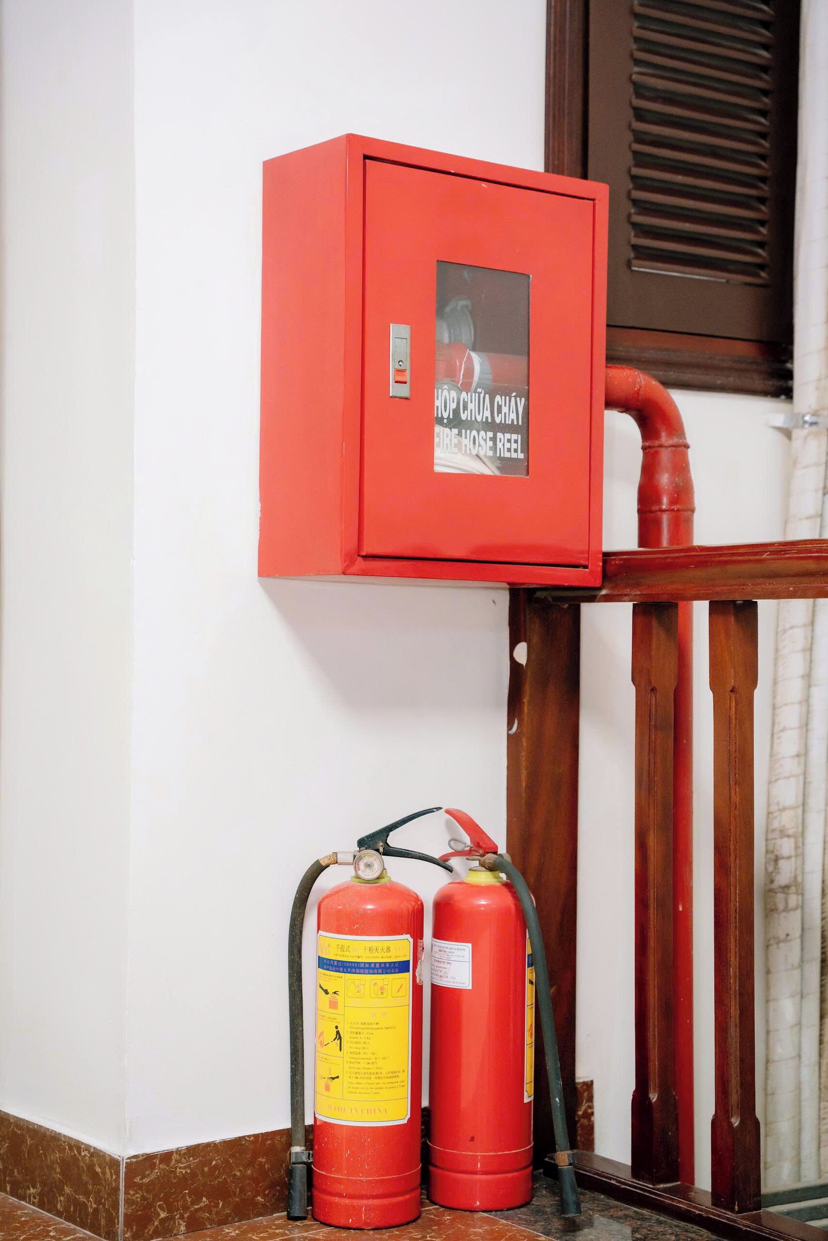 A red fire hose reel cabinet with a label indicating it is a fire hose reel.