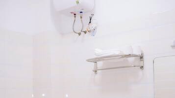 Un baño con inodoro, lavamanos, toallero y aire acondicionado de pared.