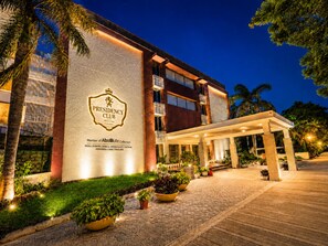 A hotel with a prominent 'Presidency Club' sign, a covered entrance, and a well-lit facade. - Presidency Club Resort & Spa (Vadodara)