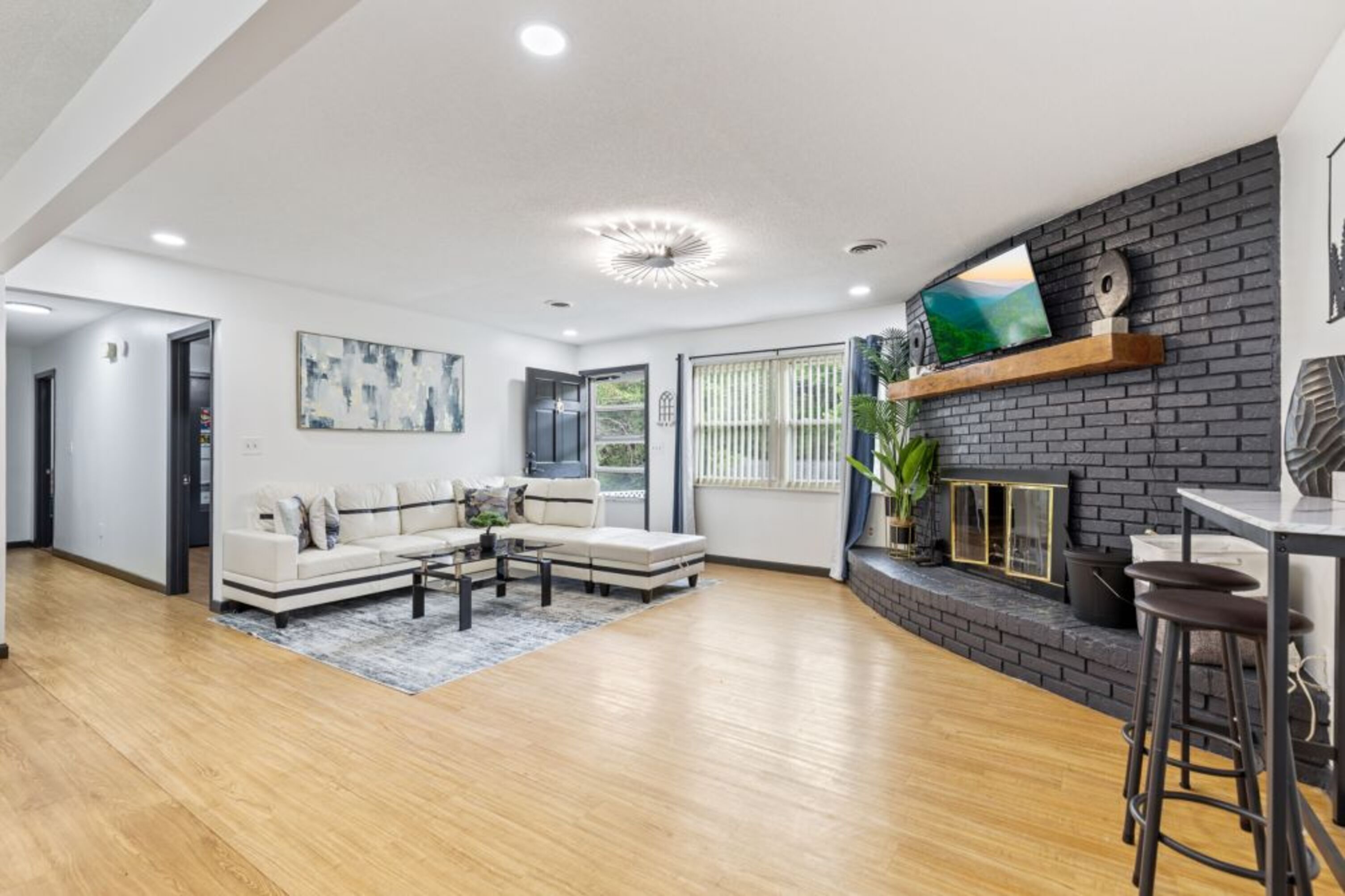 Una sala moderna con un sofá seccional, una mesa de centro y una chimenea.