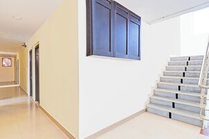Un pasillo con una escalera que sube a un piso superior.