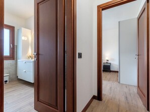 Ein Korridor mit Holztüren, die zu einem Badezimmer und einem Schlafzimmer führen.