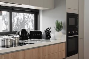 Uma cozinha moderna com forno embutido, máquina de café e torradeira.