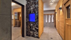 Ein modernes Badezimmer mit Steinwand, Holzschränken und einem blauen Bildschirm.
