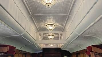 A room with a high ceiling, ornate plasterwork, and three chandeliers.