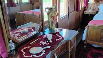 A room with a wooden bed, a dresser with a mirror, and a window with curtains.