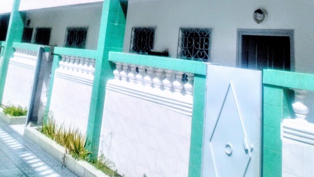 A multi-story building with balconies, a gated entrance, and a clear sky. - RESIDENCE BELLE VUE PALMERAIE (ABIDJAN)