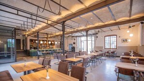 A spacious cafe with multiple tables and chairs, a bar area, and large windows allowing natural light. - Alter Hafen Marktsteft (Marktsteft)