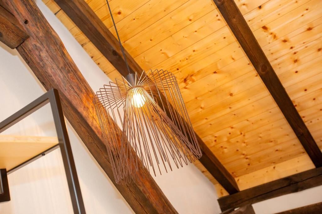 Techo con vigas de madera y una lámpara colgante.