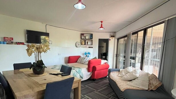 Un espace de vie moderne comprenant un coin repas, un canapé et un lit.