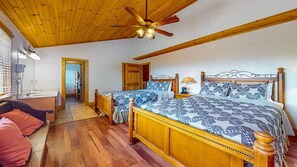 A bedroom with two wooden beds, a ceiling fan, and a wooden floor. - Moonlit Mountain Retreat | Mountain Views, Hot Tub & Fantastic Game Room (Sevierville)