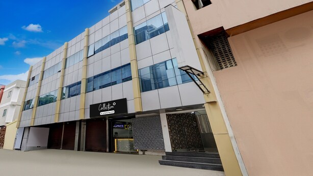 A modern building with multiple floors, large windows, and a sign indicating it is a company serviced location. - CollectionO Guduvancheri Railway Station (Chennai)