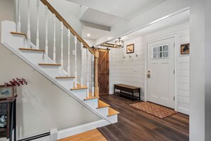 A staircase with white balusters and wooden handrails, leading to a door with a sign above it. - Mingo Manor | Across from Mingo Springs Golf Course!! (Rangeley)