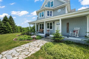 A two-story house with a porch, stone pathway, and a welcome sign. - Mingo Manor | Across from Mingo Springs Golf Course!! (Rangeley)