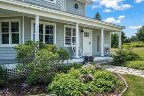 A two-story house with a covered porch, a front door, and a welcoming sign. - Mingo Manor | Across from Mingo Springs Golf Course!! (Rangeley)