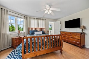 A bedroom with a wooden bed, a television, a dresser, and a ceiling fan. - Mingo Manor | Across from Mingo Springs Golf Course!! (Rangeley)
