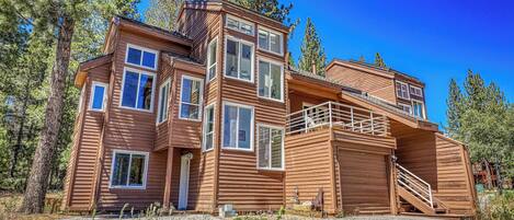 Eine mehrstöckige Holzhütte mit Balkon und Treppe.