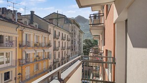 A multi-story building with balconies, a staircase, and a mountain view in the background. - Aluméa – Charming and Wellness Retreat in Central Aosta with Mountain Views (Aosta)