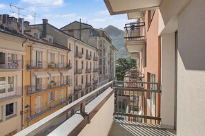 Ein mehrstöckiges Gebäude mit Balkonen, einer Treppe und Bergblick im Hintergrund.
