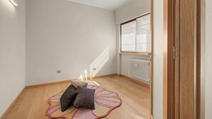 A room with a wooden floor, a radiator, a window with blinds, and a door. - Aluméa – Charming and Wellness Retreat in Central Aosta with Mountain Views (Aosta)