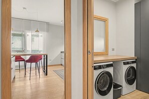 Een wasserette met twee voorladers, een houten aanrechtblad en een spiegel boven de machines.