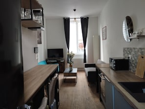 A compact living space with a kitchenette, a dining area, and a seating area. - A 5-minute drive from the Château de Flers, a family-friendly townhouse with a garden. (Flers)