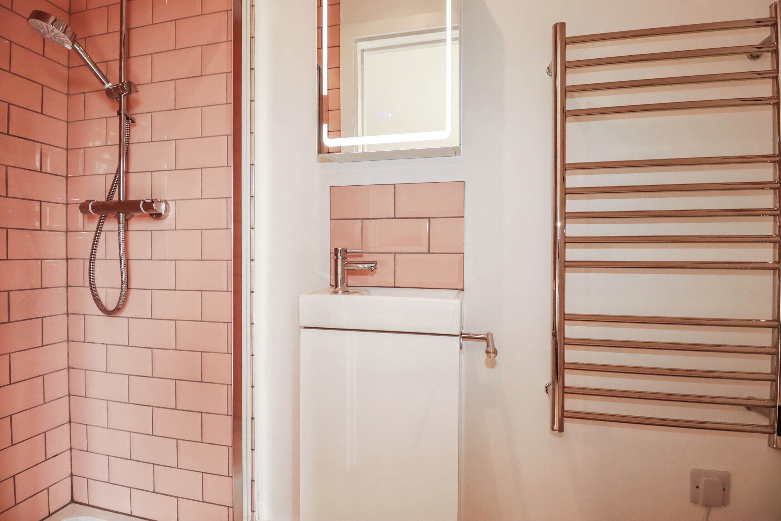 Ein Badezimmer mit Dusche, Handtuchhalter und Tür.