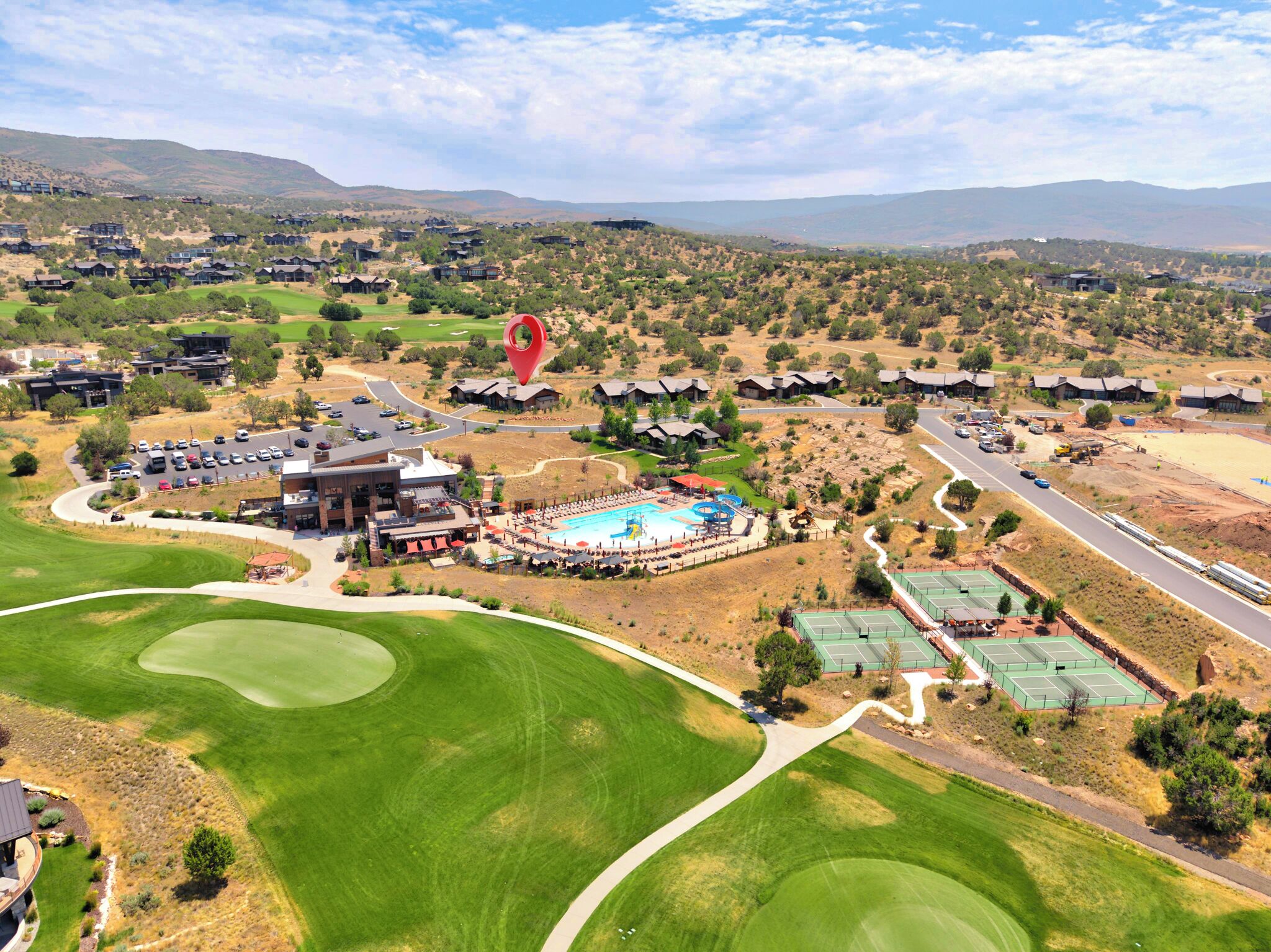Ein Golfplatz mit mehreren Gebäuden, einem Schwimmbad und Tennisplätzen.