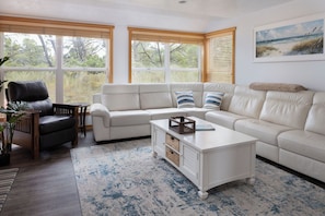 A living room with a sectional sofa, a coffee table, and a black leather chair. - 3 Min to Sand | Family Fun + Bunk Room | Sleeps 9 (Cloverdale)