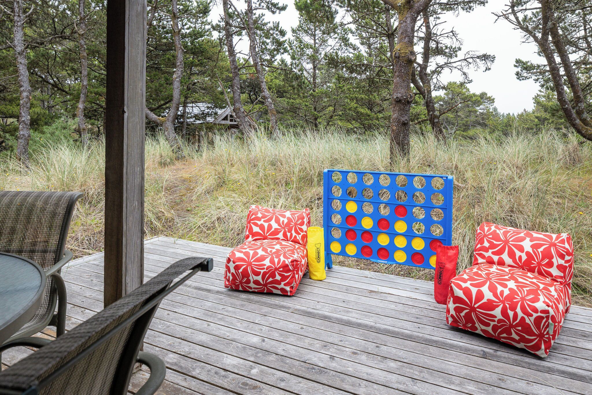 A deck with outdoor furniture, including a table and chairs, and a Connect bingo game set.
