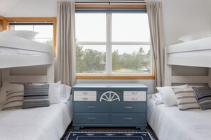 A bedroom with two bunk beds, a dresser with drawers, and a window with curtains. - 3 Min to Sand | Family Fun + Bunk Room | Sleeps 9 (Cloverdale)