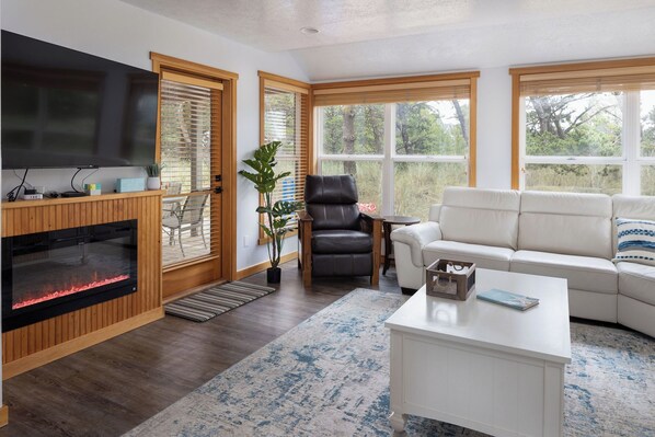A living room with a fireplace, a sofa, a coffee table, and a television.