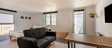 Une chambre moderne comprenant un lit, un canapé, une table à manger et un téléviseur.
