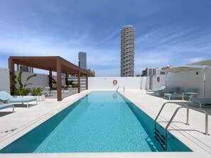 Ein Dachpool mit freiem Blick auf ein hohes, zylindrisches Gebäude im Hintergrund.
