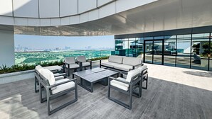 An outdoor seating area with modern furniture and a city view. - Free Housekeeping Visits During Your Stay - Stayshort - Vibrant 1-bedroom Apartment at 1 Residences West in Za Abeel (Dubai)