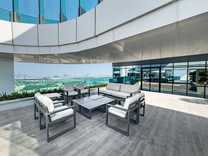An outdoor seating area with modern furniture and a city view. - Free Housekeeping Visits During Your Stay - Stayshort - Vibrant 1-bedroom Apartment at 1 Residences West in Za Abeel (Dubai)