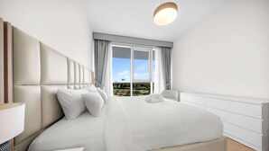 A modern hotel room with a large bed, a bedside table, and a view of the cityscape through the window. - Free Housekeeping Visits During Your Stay - Stayshort - Vibrant 1-bedroom Apartment at 1 Residences West in Za Abeel (Dubai)