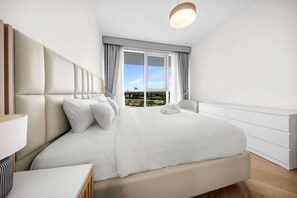 A modern hotel room with a large bed, a bedside table, and a view of the cityscape through the window. - Free Housekeeping Visits During Your Stay - Stayshort - Vibrant 1-bedroom Apartment at 1 Residences West in Za Abeel (Dubai)