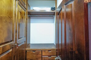 A wooden closet with a mirrored door, a shelf, and a hanging shoe rack. - Authentic Beachfront Home | Panoramic Ocean Views (Puerto Peñasco)