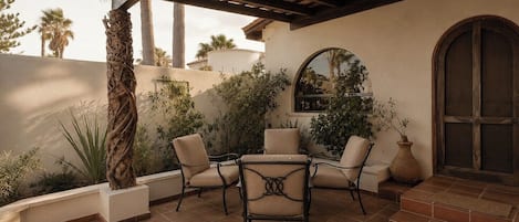 An outdoor patio with a pergola, seating area, and a view of the surrounding landscape.