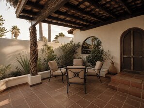 Eine Terrasse im Freien mit einer Pergola, einer Sitzgelegenheit und Blick auf die umliegende Landschaft.