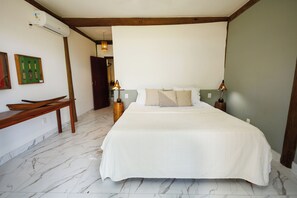 A bedroom with a large bed, a wooden bench, and a wall-mounted air conditioner. - #casa_oceano_barra_grande Luxury Villa (MARAU)